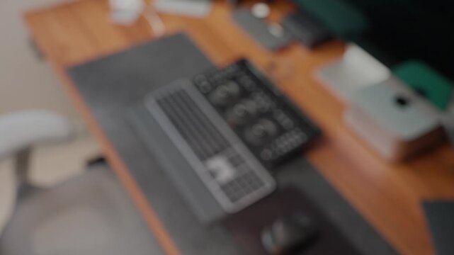Hand holding smartphone with green screen in modern workspace, finger points and gestures