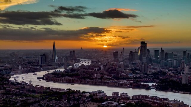 Beautiful sunset to evening time lapse view of the urban skyline of London, England, with golden sunshine and cloudscape