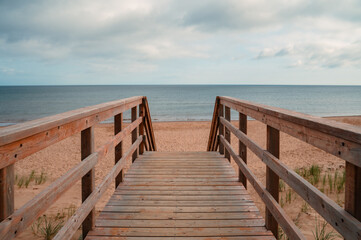 Obraz premium Wooden staircase leading down to a sandy beach in PEI
