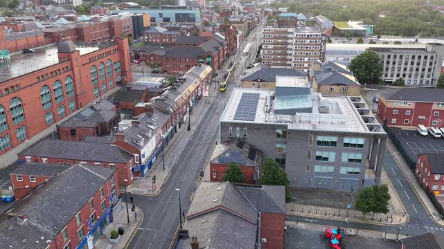 Aerial Video of a Yellow Metrolink Tram on Union Street and Spindles Car Park in Oldham