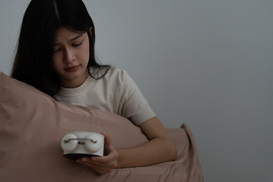 woman in bed late trying to sleep suffering insomnia, sleepless or scared in a nightmare, looking sad worried and stressed. Tired and headache or migraine waking up in the middle of the night.