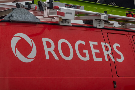 Calgary, AB, Canada - Sept 13, 2026: Close-up of white Rogers logo on red service van with ladder rack.