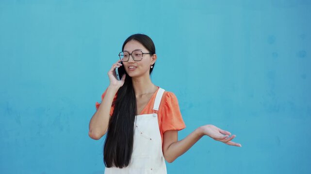 Asian woman with glasses talking on the phone