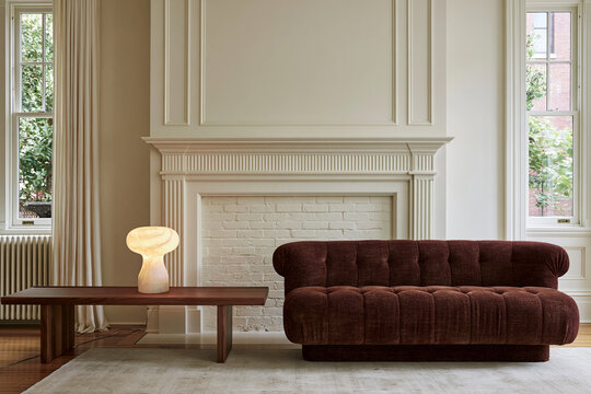 Modern heritage living room with low mulberry loveseat and sculptural alabaster lamp beside fireplace