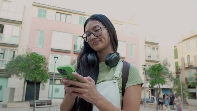 Young asian student using a smartphone outdoors in a city square