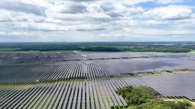 Solar panel arrays under blue sky with white clouds