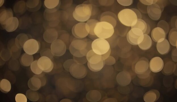 Scattered golden-yellow bokeh fairy lights in darkness, 4K video

