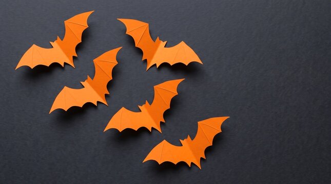 Six flat orange bat cutouts arranged dynamically against a dark background for seasonal decoration.