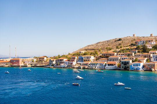 Traditional greek architecture on the sea shore of Halki island, Greece. Beautiful turquoise sea at sunny day.
