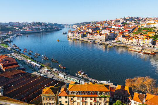 View of the old town and Douro river with boats in Porto, Portugal. Beautiful autumn cityscape at sunset.