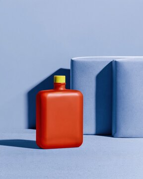 Perfume bottle in terracotta orange with a yellow cap on purple silk, a matte blank mockup for fragrance branding with copy space