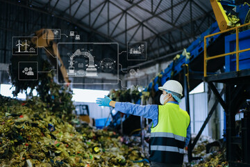 Asian engineer in hardhat using tablet with green energy and carbon neutral HUD graphics inside...