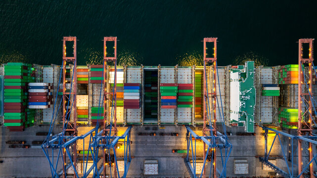 Aerial view container cargo ship loading unloading at night, Container cargo ship import export sea port, Global trade business container cargo ship freight shipping commercial trade logistic.