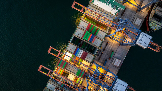 Aerial view container cargo ship loading unloading at night, Container cargo ship import export sea port, Global trade business container cargo ship freight shipping commercial trade logistic.