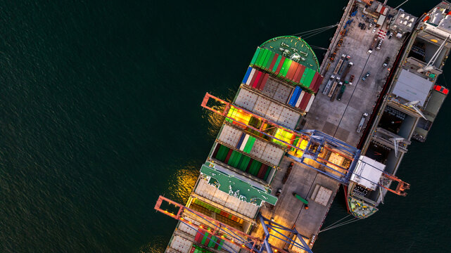 Aerial view container cargo ship loading unloading at night, Container cargo ship import export sea port, Global trade business container cargo ship freight shipping commercial trade logistic.