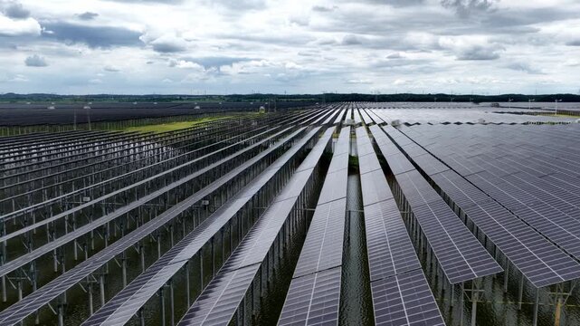 aerial view of large scale solar power plant with orderly rows of photovoltaic panels