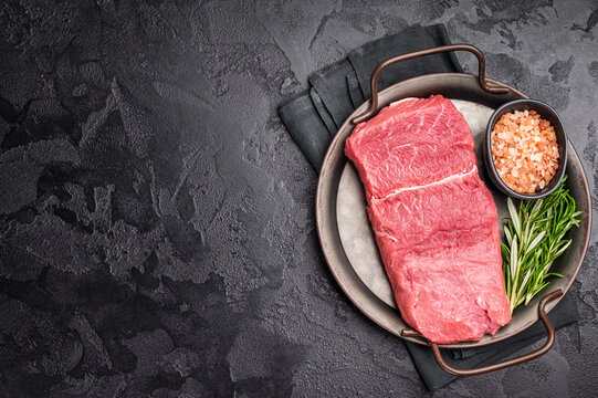 A selection of raw bison steaks arranged artfully, emphasizing their quality and texture, inviting culinary creativity in the kitchen. black background. top view