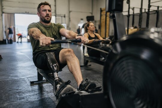 Functional Fitness Race athlete with prosthetic leg rowing machine workout