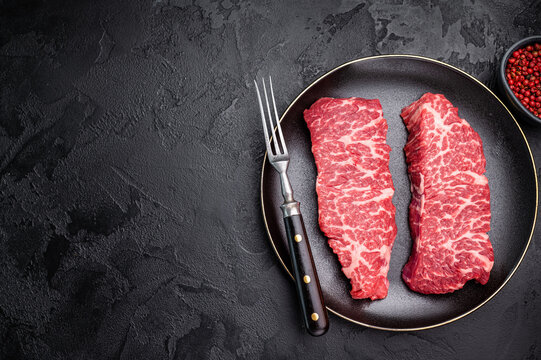 High-quality Denver cut, featuring a perfect balance of fat and meat steak. A great choice for those seeking a flavorful and juicy steak experience. black background. top view