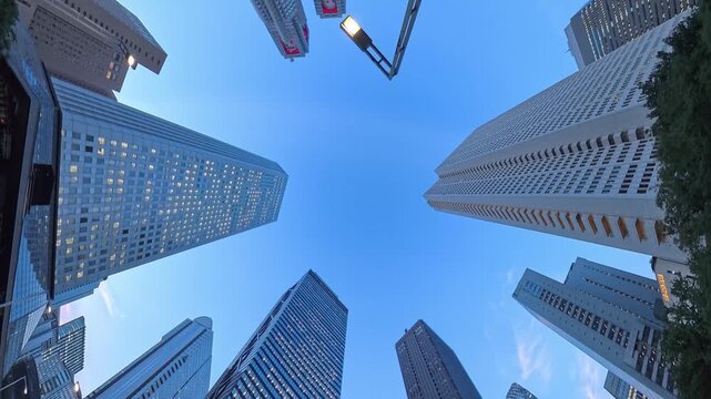 TOKYO, JAPAN - JUL 2026 : Skyscrapers and office buildings in Nishi-Shinjuku business district. Looking up from below at sunset. Japanese corporate business, financial hub and urban technology concept