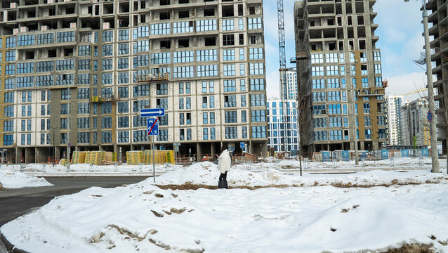 A bustling construction site set against the backdrop of winter showcases several new buildings currently under development. These structures are emerging prominently near 