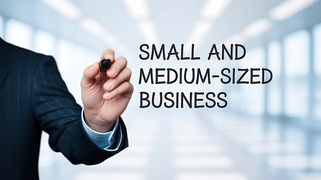 Business professional's hand writing 'Small and Medium-Sized Business' on an interactive virtual screen, symbolizing strategic planning and growth for enterprises
