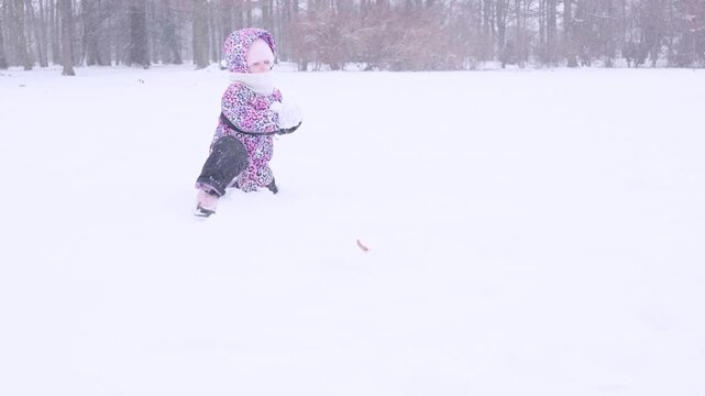 Toddler cold weather. Child enjoying snow game with parent. Joyful childhood concept.