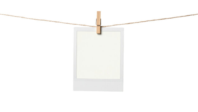 Blank instant photo frame clipped to twine, isolated on transparent background