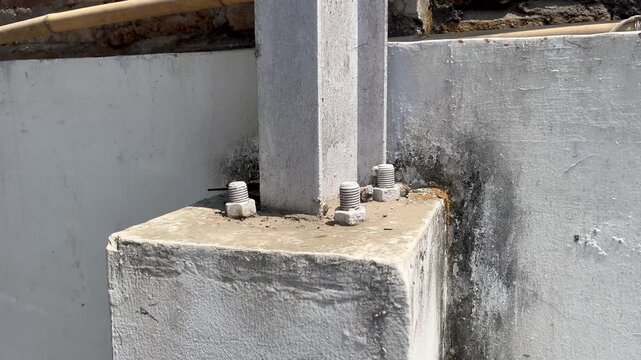 Close up of structural steel column connection on weathered concrete