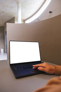 Vertical mockup image of a woman working on laptop computer with blank white desktop screen