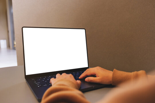 Mockup image of a woman working and typing on laptop computer with blank white desktop screen