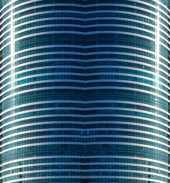 a close-up of a modern curved skyscraper glass facade with horizontal spandrel bands and tinted windows