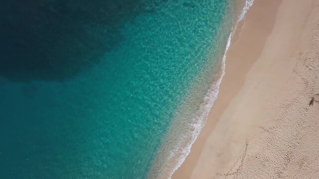 Aerial top down view of the sandy beach with powerful waves