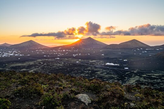 Sunrise behind volcanic peaks, sun star, Los Volcanes Natural Park, Lanzarote, Canary Islands, Spain