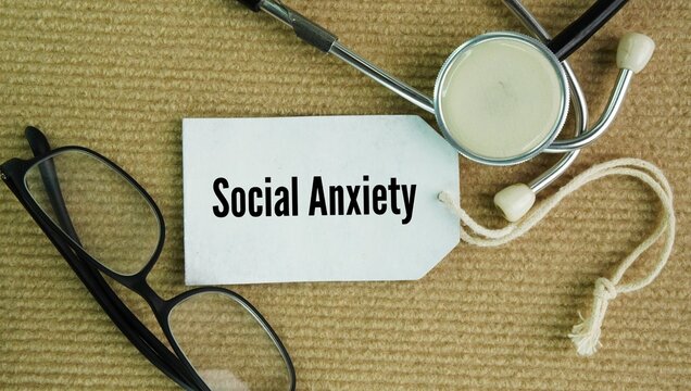 Stethoscope and paper tag with the words Social anxiety, mental health condition that causes an intense, ongoing fear of being watched, judged, or humiliated by others in social settings