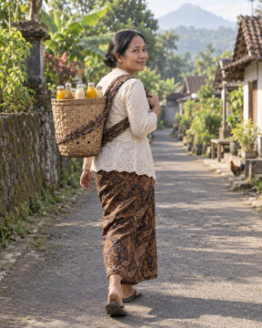 Indonesian Jamu Gendong Seller Carrying Herbal Drink Bottles on a Village Lane