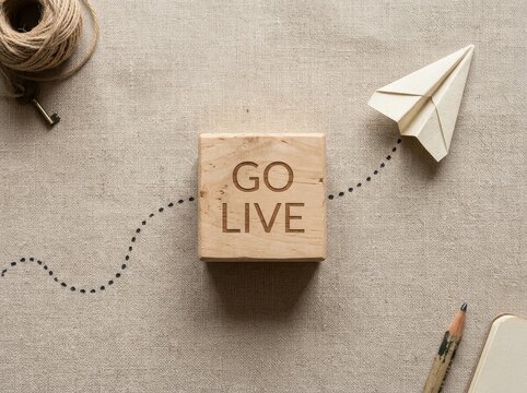 Wooden block with words Go Live and paper airplane