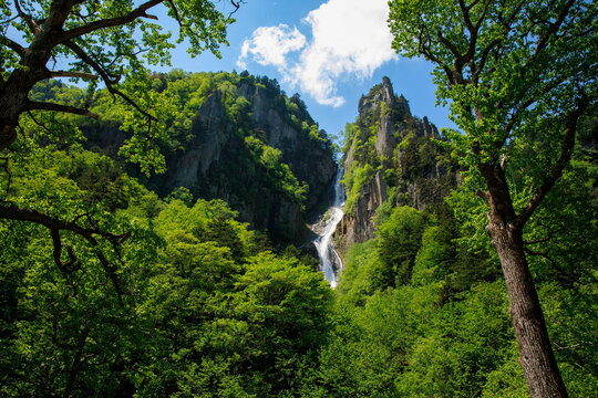 Ryusei and Ginka Waterfalls flowing down steep rocky cliff in Sounkyo Gorge, Hokkaido, Japan