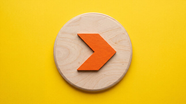 Orange arrow on wooden circle against yellow background symbolizing direction and progress concept
