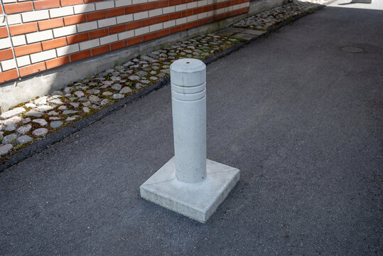 Concrete traffic bollard blocking vehicle access in residential building passageway