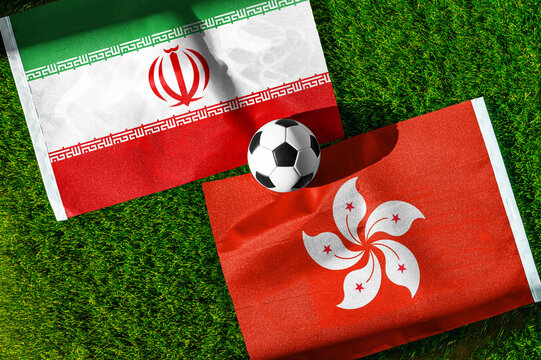 Iran vs. Hong Kong football match. National flags on green grass with soccer ball in the middle. Football background for international match.