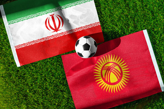 Iran vs. Kyrgyzstan football match. National flags on green grass with soccer ball in the middle. Football background for international match.