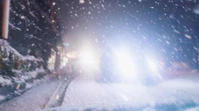 4K POV shot of a vehicle driving on a road during heavy snowfall in winter season at Manali in Himachal Pradesh, India. Vehicle driving on road during the snowfall at night. Winter travel background.