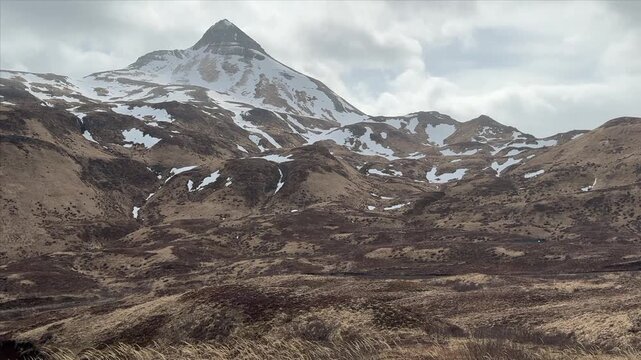 Wide angle landscape shot of snow-streaked slopes of Pyramid Peak, Unalaska Island.