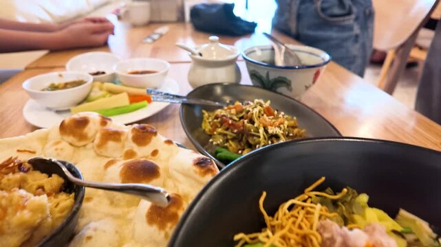 Variety of Traditional Burmese Food Served on a Wooden Restaurant Table