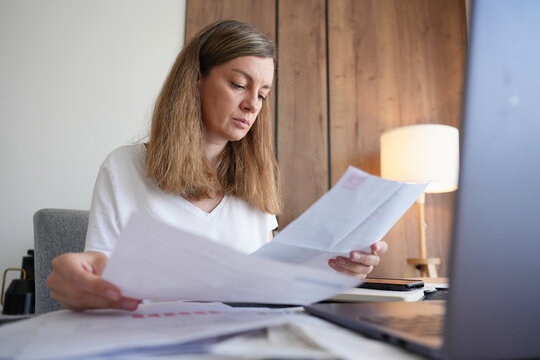 Woman reviewing household bills and expenses at home