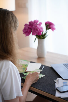 Woman counting euro cash while planning household budget at home