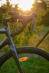 Fototapeta premium Close-up of a gravel bike with front wheel, drop handlebars at sunset