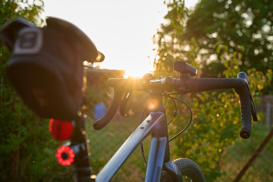 Rear view of bicycle with front and rear lights at sunset