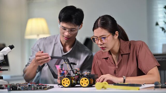 Young Man and Woman Working on Robotics Project in Modern Laboratory
